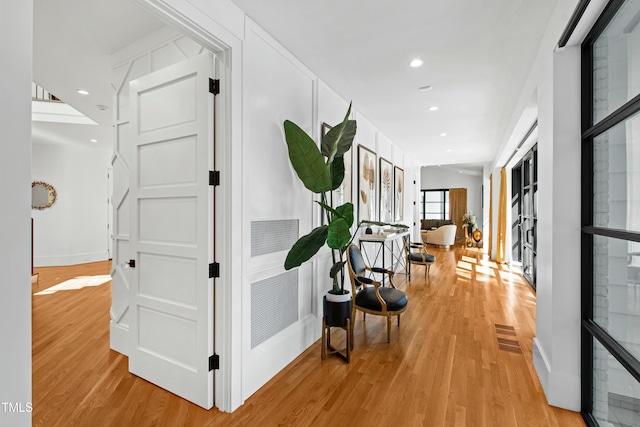 hall featuring recessed lighting, light wood-style flooring, and baseboards