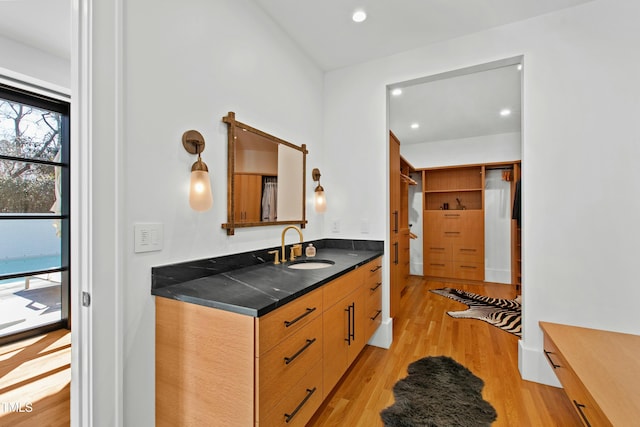 kitchen with dark countertops, recessed lighting, light wood-style floors, a sink, and modern cabinets