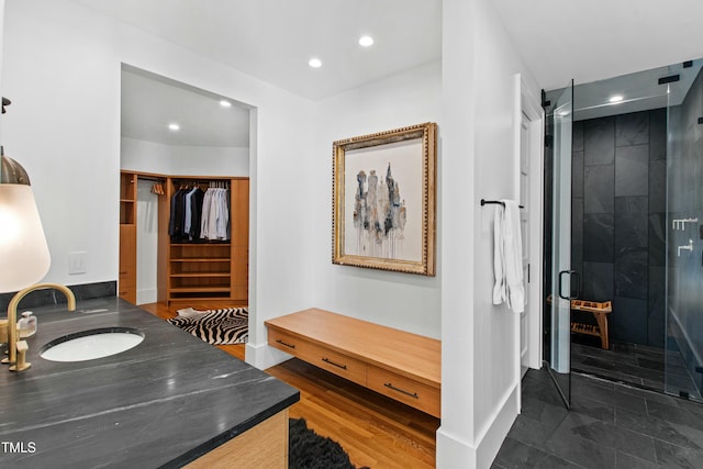 bathroom featuring a spacious closet, a stall shower, vanity, and recessed lighting