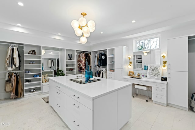 walk in closet with marble finish floor and a chandelier