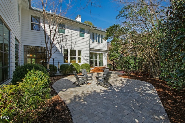 back of house with a patio area and a chimney