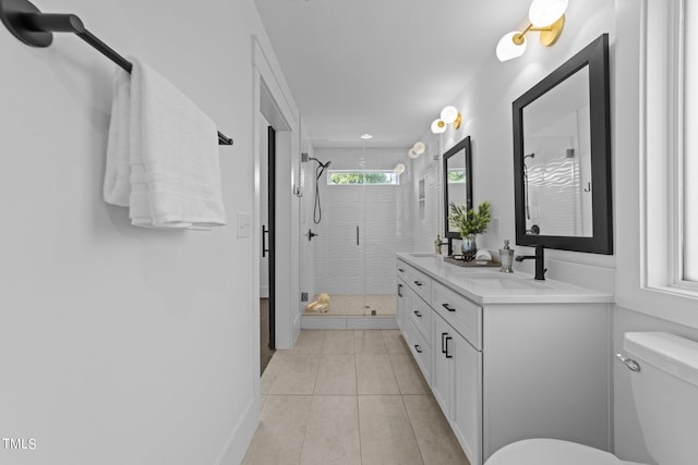 bathroom with a shower with door, vanity, tile patterned flooring, and toilet