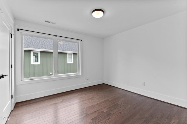 empty room with dark hardwood / wood-style flooring