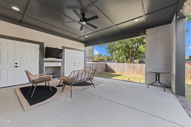 view of patio / terrace featuring ceiling fan and exterior fireplace