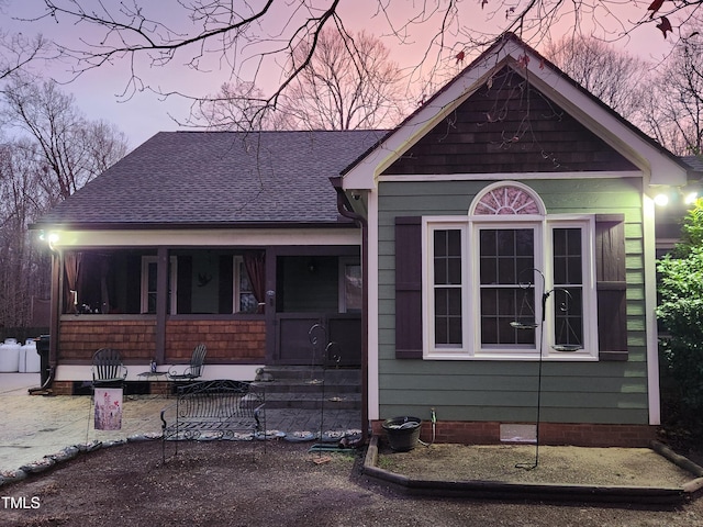 view of front of property with crawl space, a porch, and a shingled roof