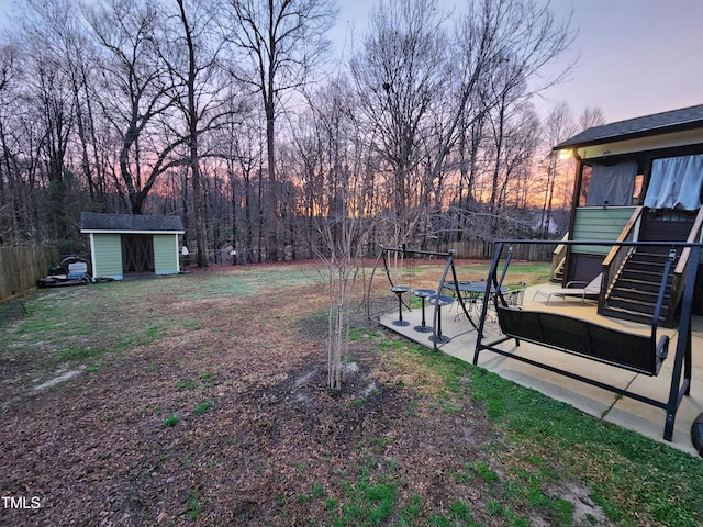 yard at dusk featuring a shed and a patio