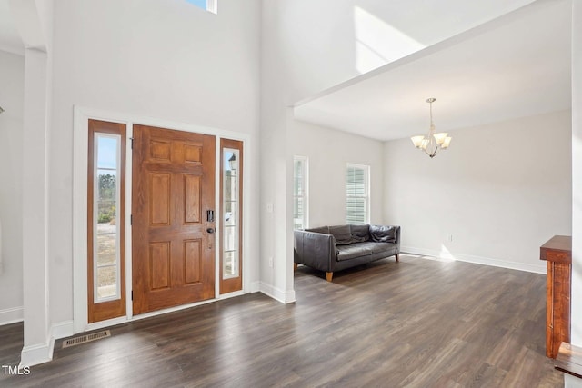 foyer featuring a notable chandelier, visible vents, dark wood finished floors, and a wealth of natural light