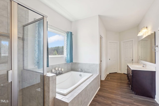 full bath with a garden tub, a shower stall, wood finished floors, and vanity