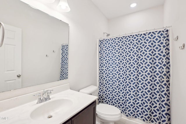 bathroom featuring curtained shower, vanity, and toilet