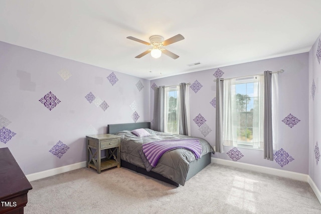 carpeted bedroom with visible vents, a ceiling fan, and baseboards