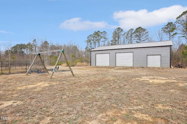 exterior space with a garage, fence, a playground, and an outdoor structure