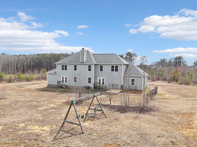 back of property featuring a chimney, fence, and roof with shingles