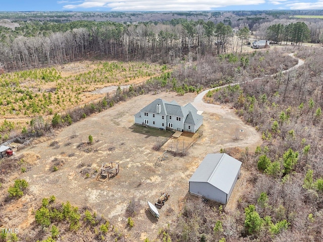 birds eye view of property featuring a wooded view and a rural view