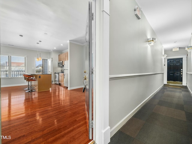 corridor featuring crown molding, dark wood-style flooring, recessed lighting, and baseboards