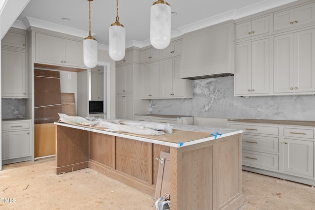 kitchen with custom range hood, backsplash, gray cabinetry, ornamental molding, and a kitchen island