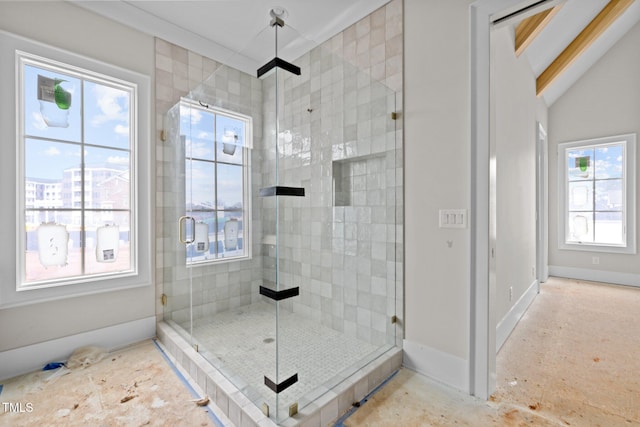 bathroom with a shower stall, baseboards, and vaulted ceiling