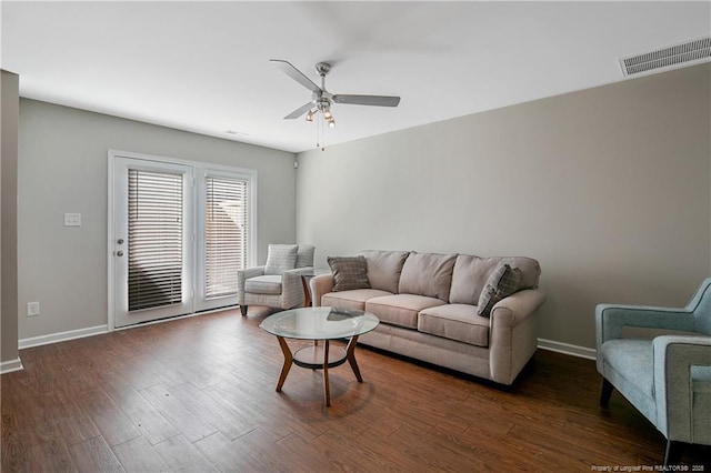 living room with dark wood-type flooring and ceiling fan