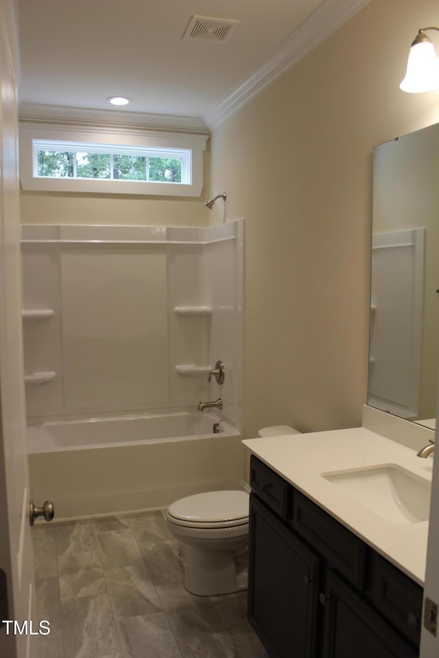 full bathroom with vanity, crown molding, tub / shower combination, and toilet