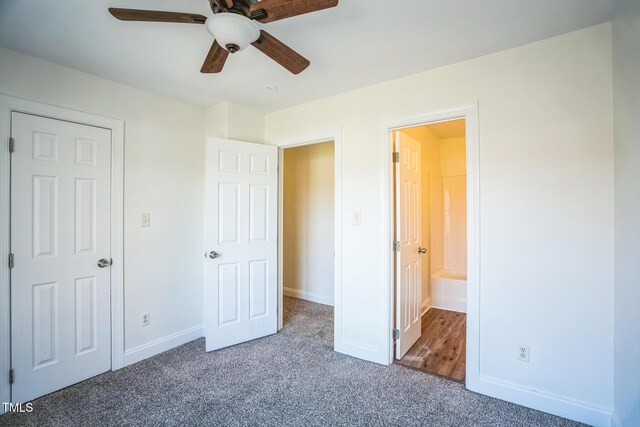 unfurnished bedroom featuring baseboards, ceiling fan, connected bathroom, and carpet