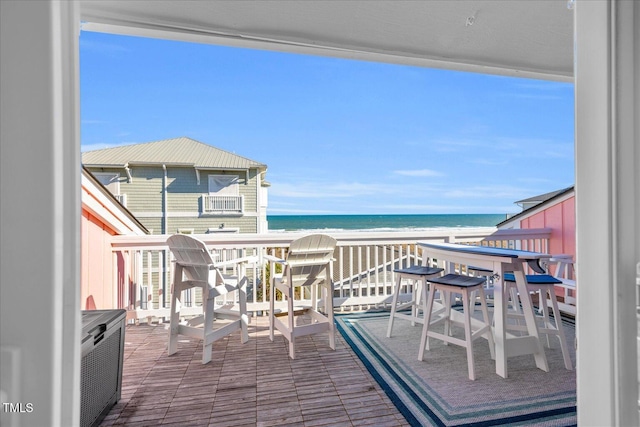 balcony with a water view and a view of the beach