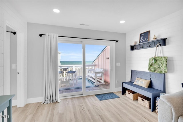 doorway to outside with a water view and light hardwood / wood-style flooring