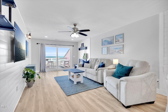 living room with light hardwood / wood-style flooring and ceiling fan