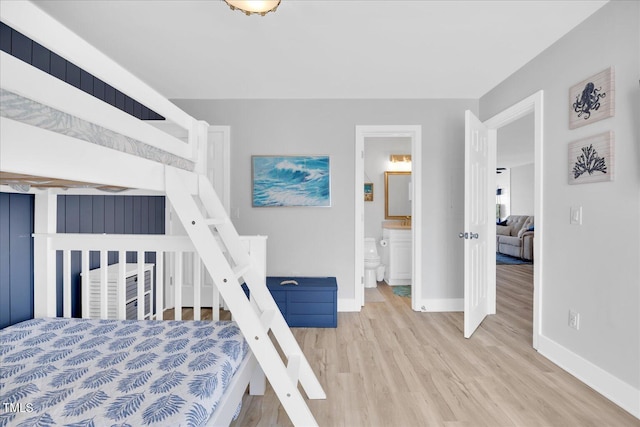 bedroom with ensuite bathroom and light wood-type flooring