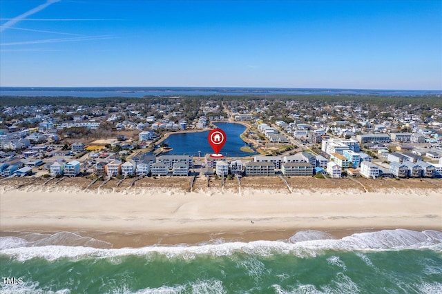 birds eye view of property with a water view and a beach view