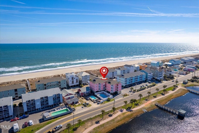 birds eye view of property featuring a water view and a beach view