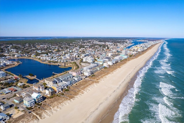 birds eye view of property with a water view and a beach view