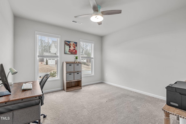 office area featuring light carpet, baseboards, visible vents, and a ceiling fan