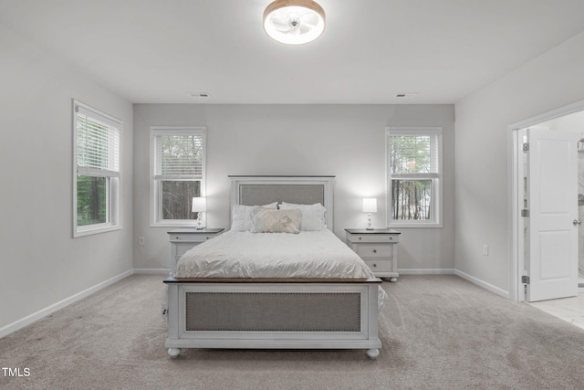 bedroom with light carpet, visible vents, and baseboards