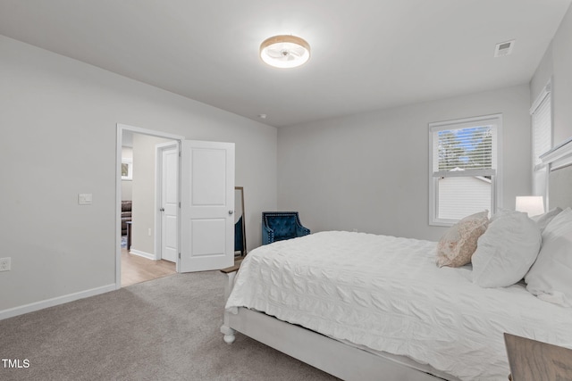 bedroom featuring light carpet, visible vents, and baseboards