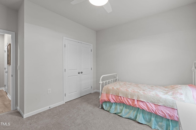 bedroom with a ceiling fan, carpet, a closet, and baseboards