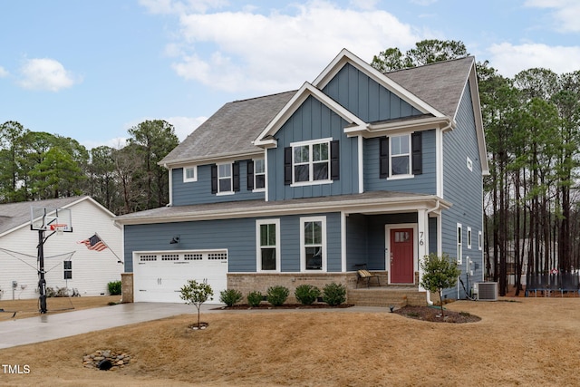 craftsman-style home featuring brick siding, concrete driveway, an attached garage, central AC unit, and board and batten siding