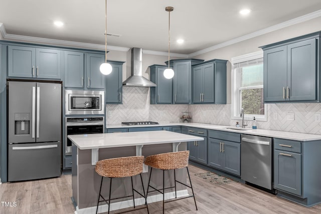 kitchen with wall chimney exhaust hood, ornamental molding, a center island, stainless steel appliances, and pendant lighting