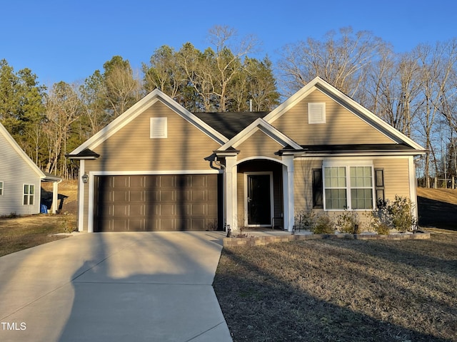 view of front of home featuring a garage, driveway, and a front yard