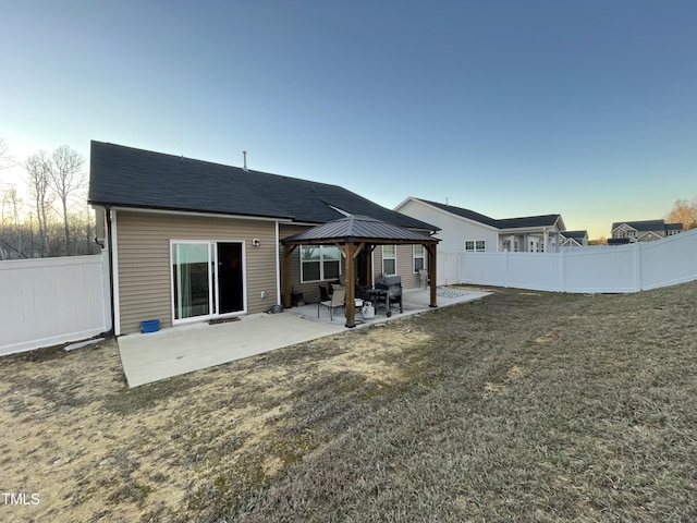 back of house featuring a yard, a fenced backyard, a patio, and a gazebo