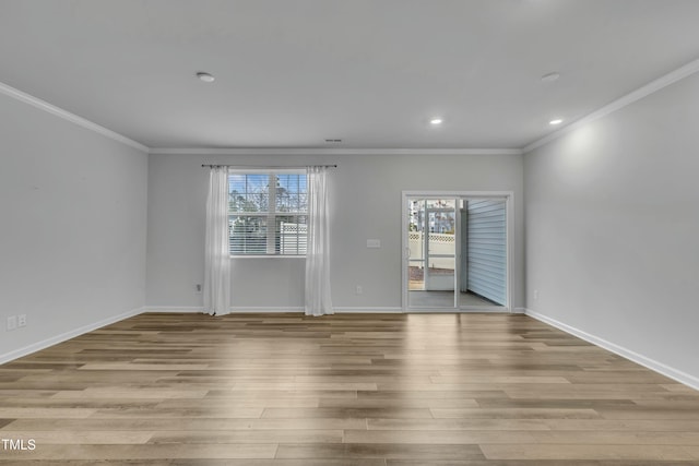 empty room featuring ornamental molding, a healthy amount of sunlight, and light hardwood / wood-style flooring