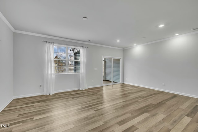 unfurnished room with ornamental molding and light wood-type flooring