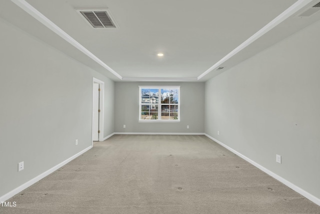 carpeted empty room with a tray ceiling