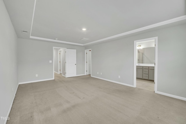 unfurnished bedroom with connected bathroom and light colored carpet