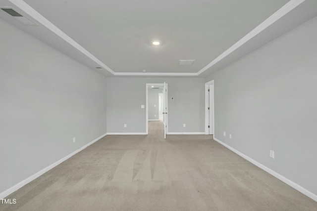 carpeted spare room featuring a tray ceiling