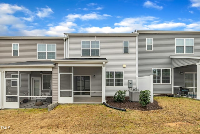 rear view of property featuring cooling unit, a yard, a sunroom, and a patio area