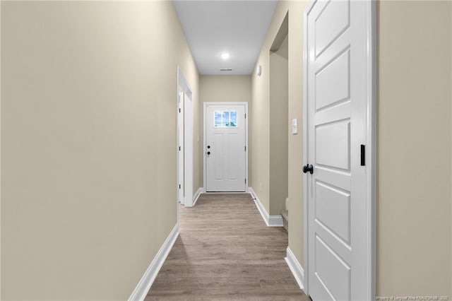 corridor with light hardwood / wood-style floors