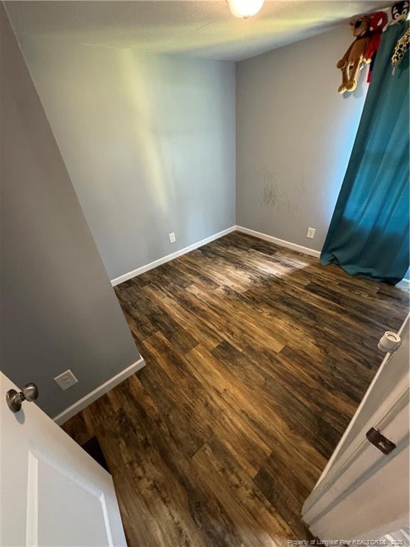 unfurnished room with dark hardwood / wood-style floors