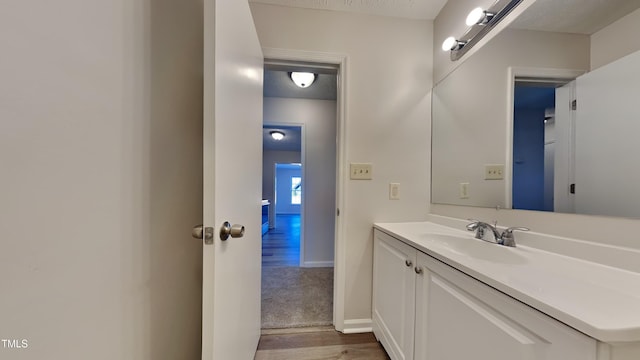 bathroom featuring a textured ceiling, vanity, and wood-type flooring