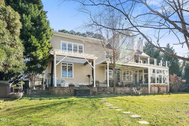 back of house featuring a sunroom and a lawn