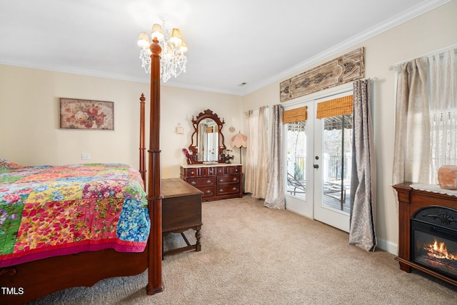 carpeted bedroom with access to exterior, a glass covered fireplace, crown molding, and french doors