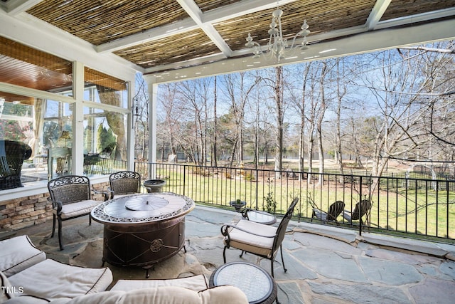 sunroom with coffered ceiling, a notable chandelier, and beamed ceiling